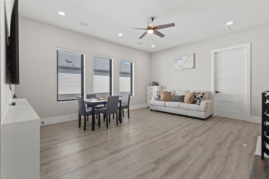 Living area featuring light wood finished floors, recessed lighting, and a ceiling fan