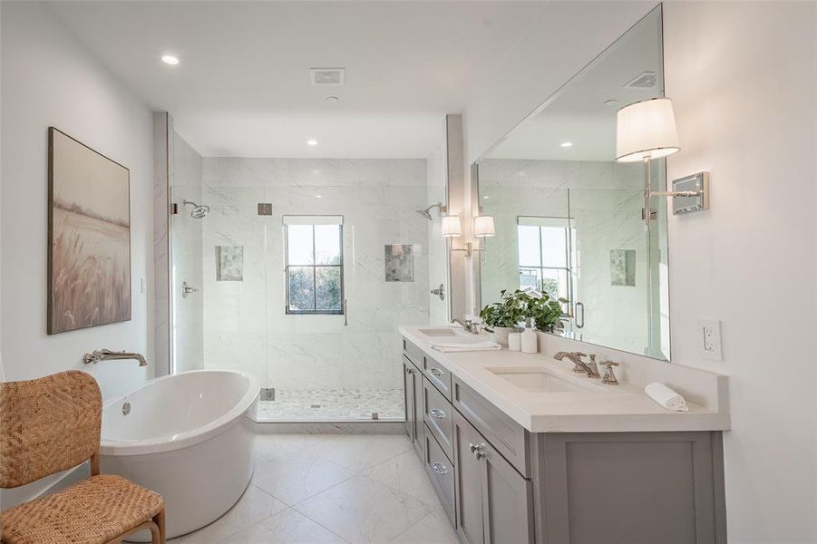 Bathroom featuring vanity and separate shower and tub