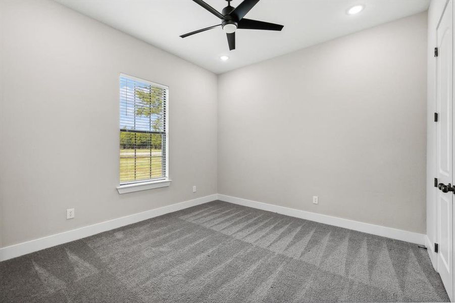 Carpeted spare room with ceiling fan