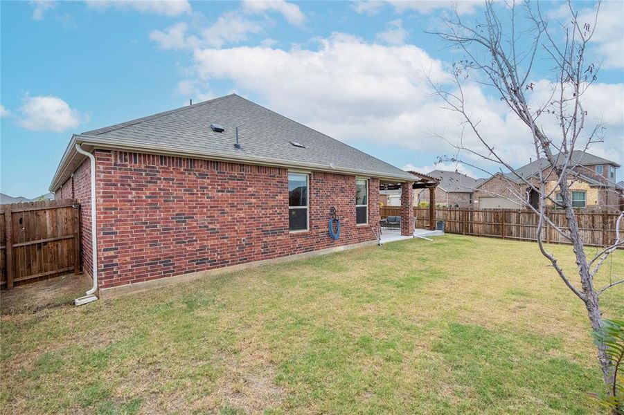 Rear view of house featuring a yard and a patio area