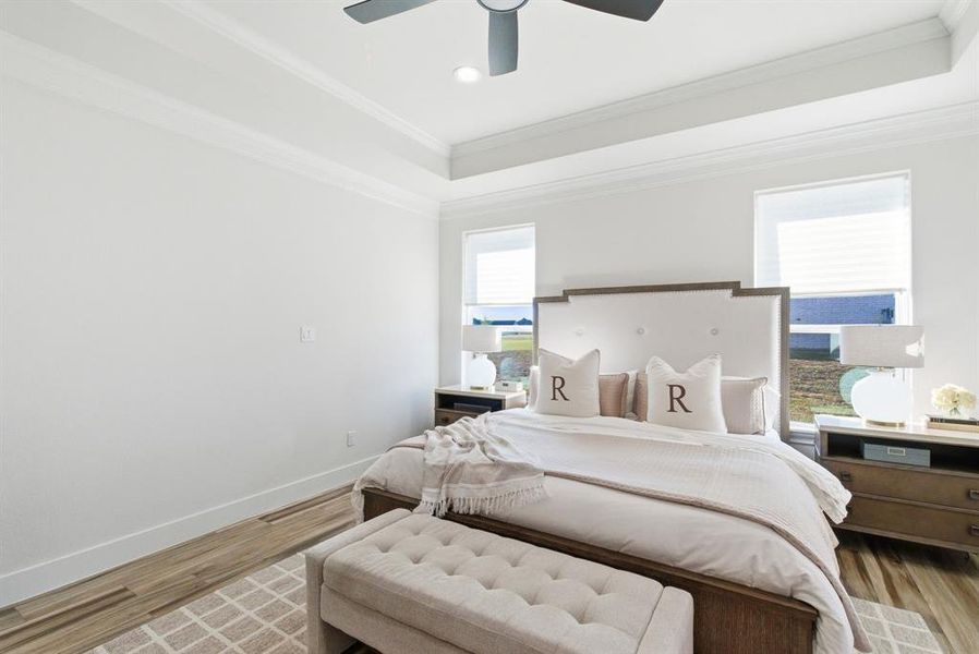 Bedroom with ornamental molding, wood finished floors, a tray ceiling, a ceiling fan, and recessed lighting