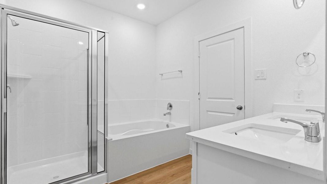 Modern primary bathroom with double vanities, granite countertops, and a glass-enclosed shower with a walk-in closet. Modern primary bathroom with double vanities, granite countertops, and a glass-enclosed shower with a walk-in closet.
