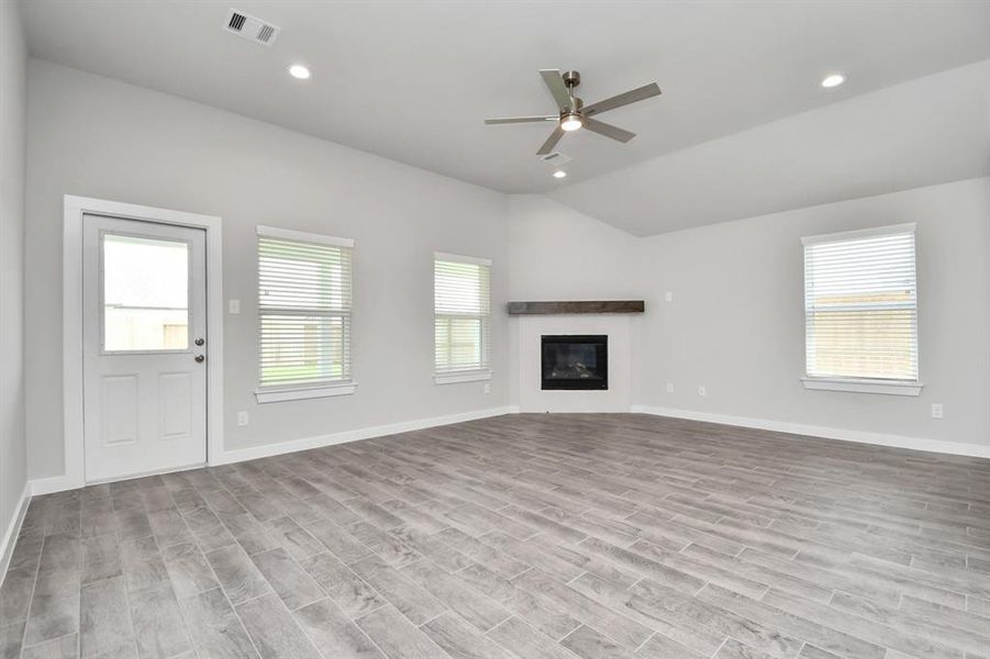 Spacious family room with large windows for natural light. Another view of the kitchen and massive island.  Sample photo of completed plan. As built color and selections may vary.