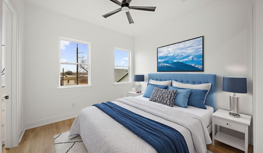 Virtually Staged: Secondary Bedroom with luxury vinyl plank floors, large windows, a ceiling fan, and a functional walk-in closet along with an en-suite bathroom.