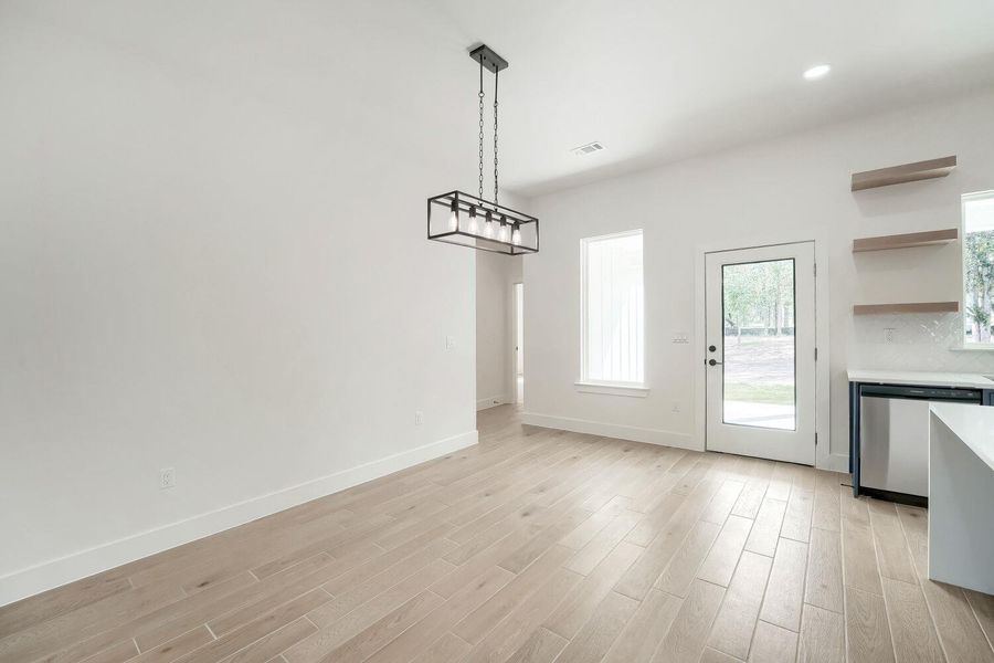A well-lit interior space features sleek wood-look tile flooring and modern light fixtures.
