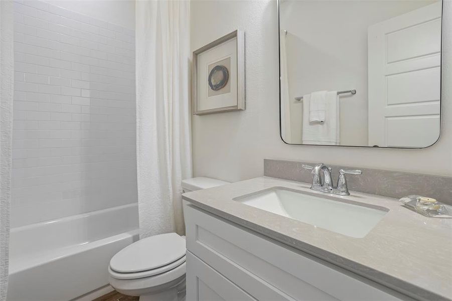 Full bathroom featuring shower / tub combo, toilet, and vanity