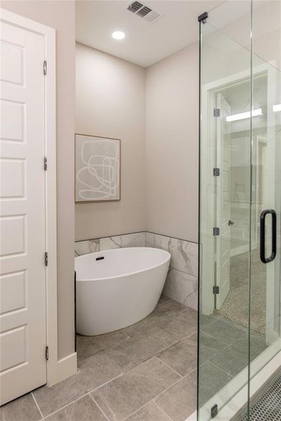 Bathroom with walk in shower and tile flooring