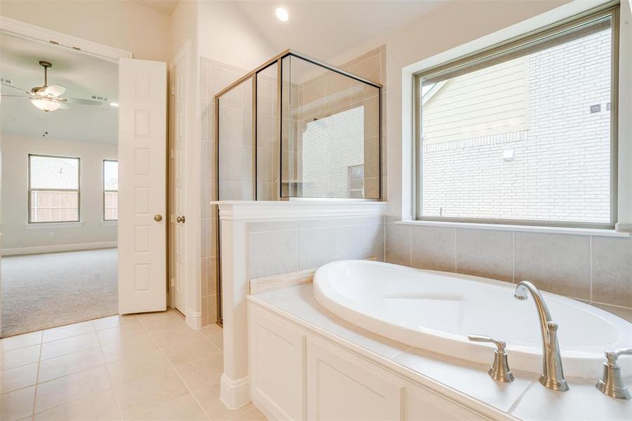 Bathroom with tile patterned flooring, independent shower and bath, and ceiling fan