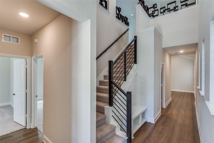 Stairway featuring wood finished floors, recessed lighting, and a high ceiling Stairway featuring wood finished floors, recessed lighting, and a high ceiling