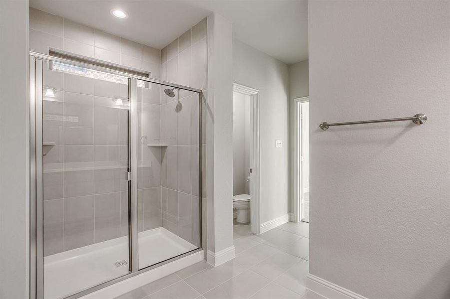 Full bath featuring a stall shower, light tile patterned floors, and recessed lighting Full bath featuring a stall shower, light tile patterned floors, and recessed lighting