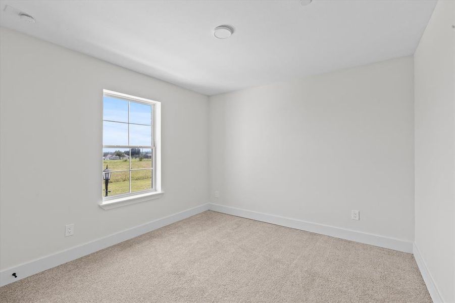 Carpeted empty room featuring baseboards