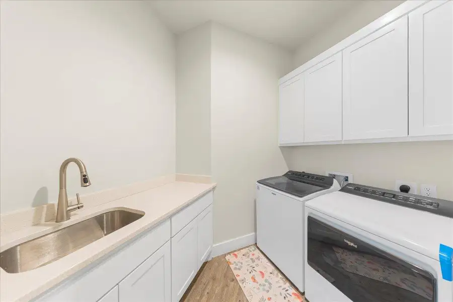 Laundry room with washing machine and clothes dryer, cabinet space, and light wood-style flooring Laundry room with washing machine and clothes dryer, cabinet space, and light wood-style flooring