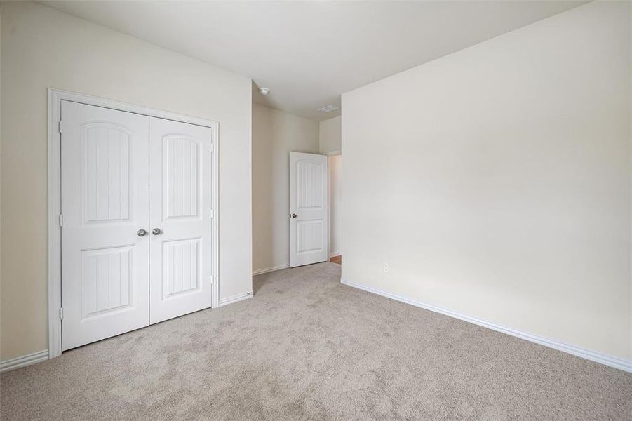 Unfurnished bedroom featuring carpet flooring and a closet