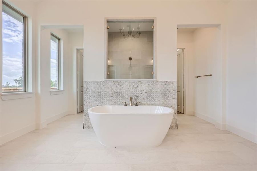 Bathroom featuring tile walls, shower with separate bathtub, and tile patterned flooring