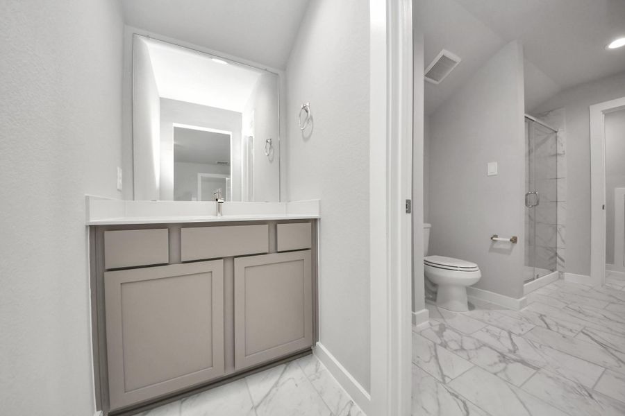 Experience convenience in the secondary bathroom, designed for Jack and Jill arrangements, now with a separate vanity area. This well-appointed space showcases stylish tile flooring, a bath/shower combo with an elegant tile surround, and light-stained wood cabinets. The beautiful light countertop adds a touch of sophistication, combining functionality and aesthetics seamlessly. Sample photo of completed home with similar floor plan. Actual colors and selections may vary. Experience convenience in the secondary bathroom, designed for Jack and Jill arrangements, now with a separate vanity area. This well-appointed space showcases stylish tile flooring, a bath/shower combo with an elegant tile surround, and light-stained wood cabinets. The beautiful light countertop adds a touch of sophistication, combining functionality and aesthetics seamlessly. Sample photo of completed home with similar floor plan. Actual colors and selections may vary.