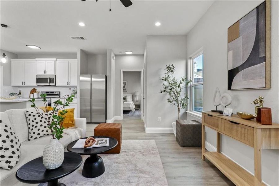 Living room featuring ceiling fan and light wood-type flooring