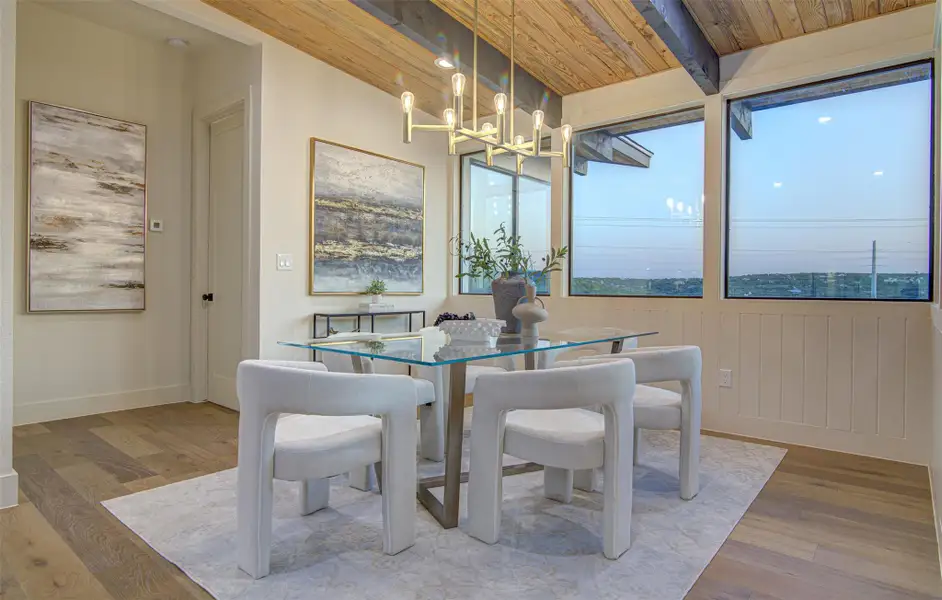 Dining area with wood finished floors, a chandelier, wooden ceiling with exposed beams, and baseboards Dining area with wood finished floors, a chandelier, wooden ceiling with exposed beams, and baseboards