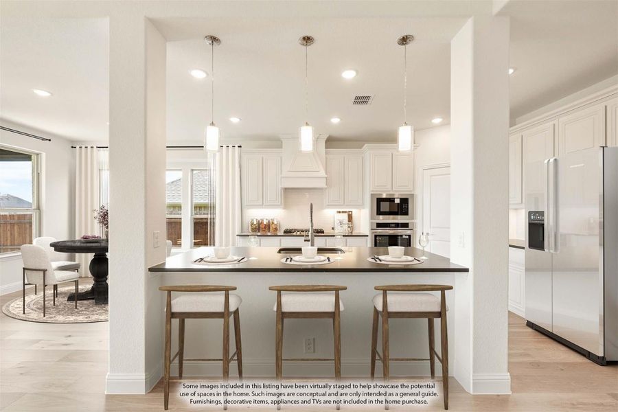 Kitchen island with dark countertop and three bar stools, white cabinets, pendant lights, and stainless steel appliances Kitchen island with dark countertop and three bar stools, white cabinets, pendant lights, and stainless steel appliances
