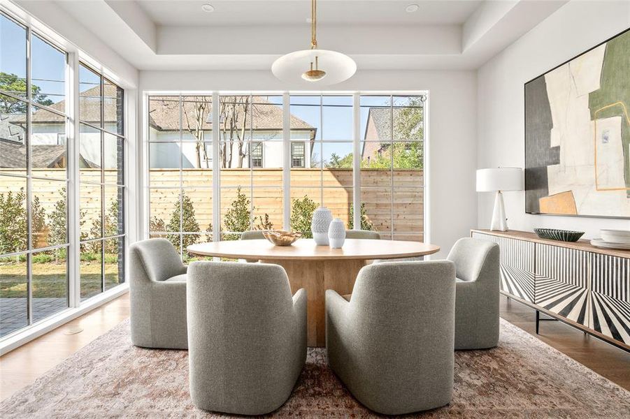 Just off the kitchen and framed by a white oak cased opening, this inviting breakfast room is bathed in natural light from large windows with views of the north lawns. Elegant white oak hardwood floors anchor the space.