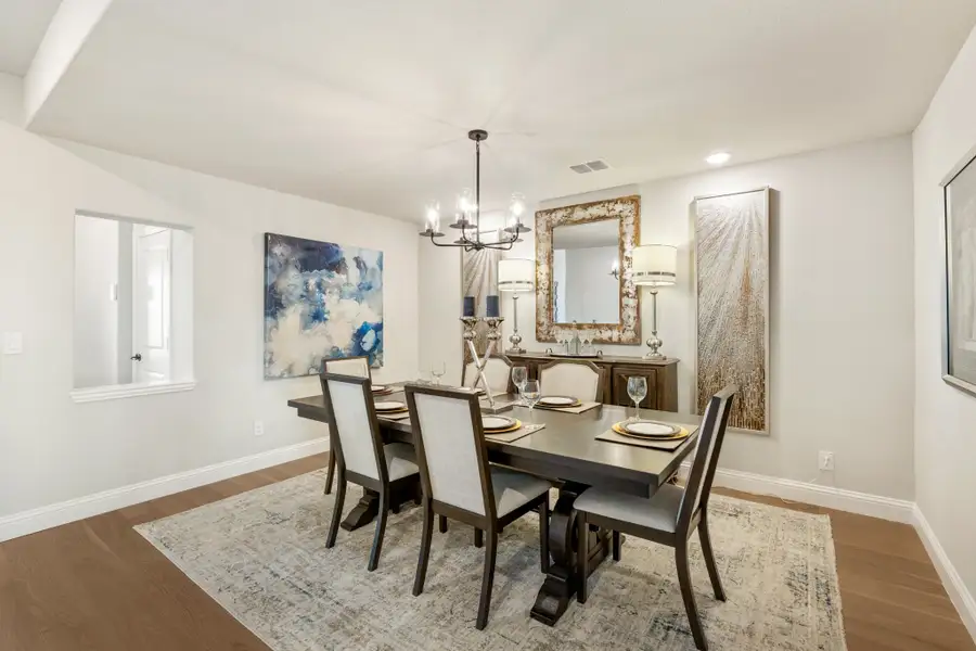 Formal dining room with dark wood table, six chairs, chandelier, and hardwood floors