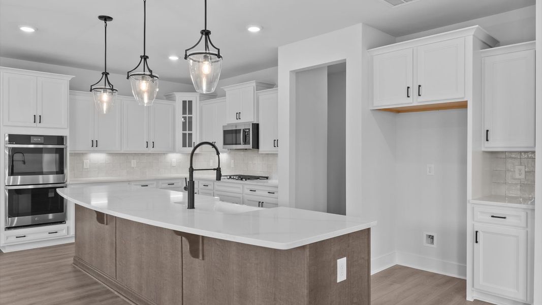 Tasteful design meets functional luxury in this kitchen with a 9-foot island and modern pendant lighting