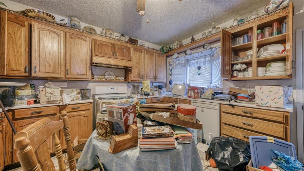 Kitchen featuring white dishwasher and a textured ceiling