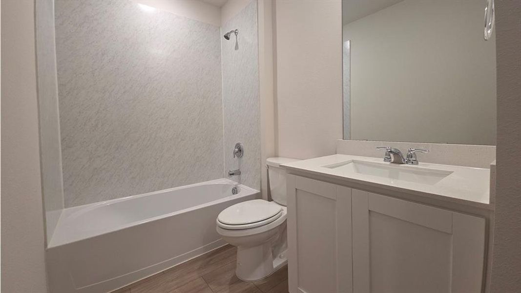Full bathroom featuring a white vanity with an integrated sink, chrome faucet, and expansive mirror