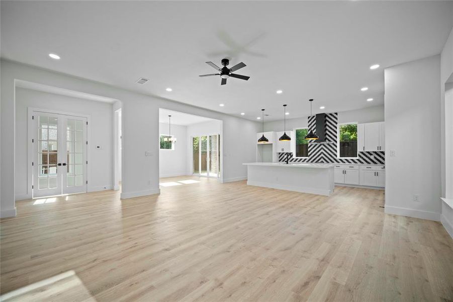 Unfurnished living room with recessed lighting, a ceiling fan, light wood-style floors, and french doors