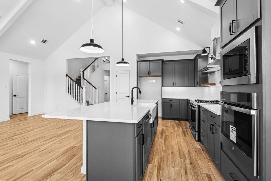 Chef-worthy kitchen with grey cabinets and quartz countertops Chef-worthy kitchen with grey cabinets and quartz countertops