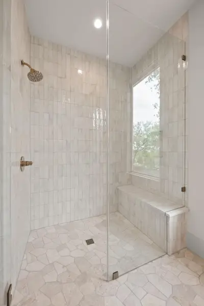 A well-appointed shower space features a built-in bench and large window for natural light. A well-appointed shower space features a built-in bench and large window for natural light.
