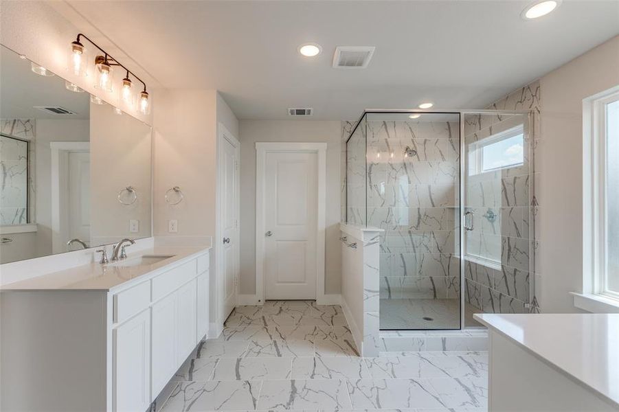 Bathroom featuring walk in shower, tile patterned floors, and vanity