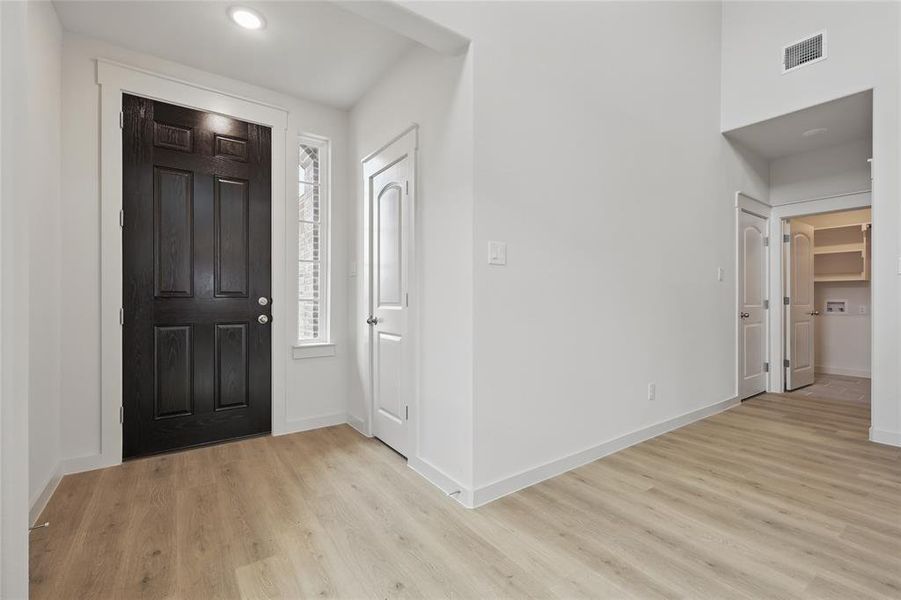 Entryway with light wood-style flooring and baseboards