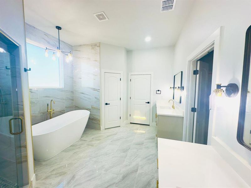 Bathroom featuring vanity and independent shower and bath