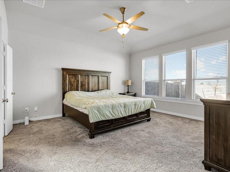 Carpeted bedroom featuring ceiling fan