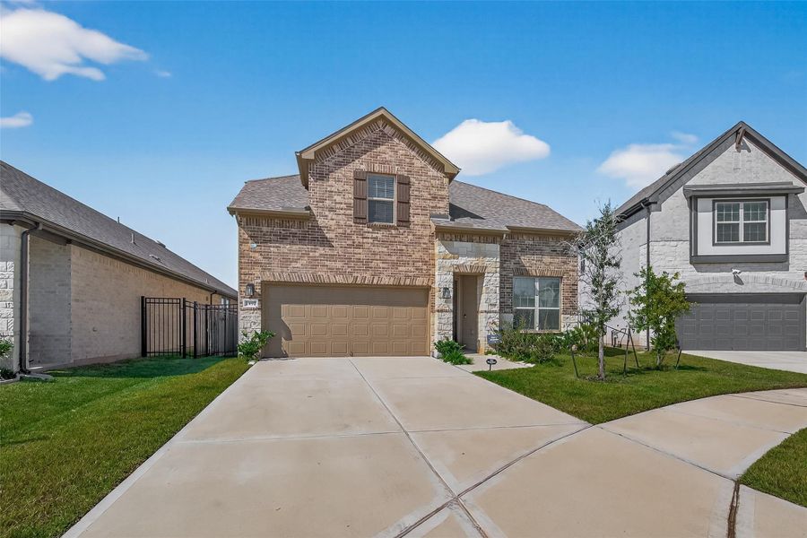 Front exterior of a new home in Sunterra, Katy, TX, highlighting curb appeal (Image 2).