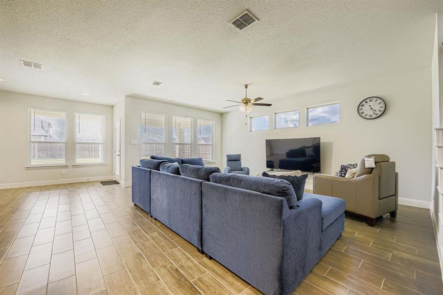 Living area with wood tiled floors, a textured ceiling, and ceiling fan Living area with wood tiled floors, a textured ceiling, and ceiling fan