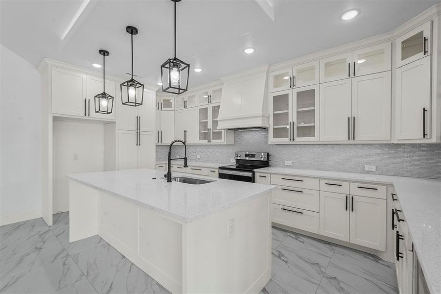 Kitchen with white cabinetry, light stone counters, decorative light fixtures, sink, and stainless steel range with electric cooktop