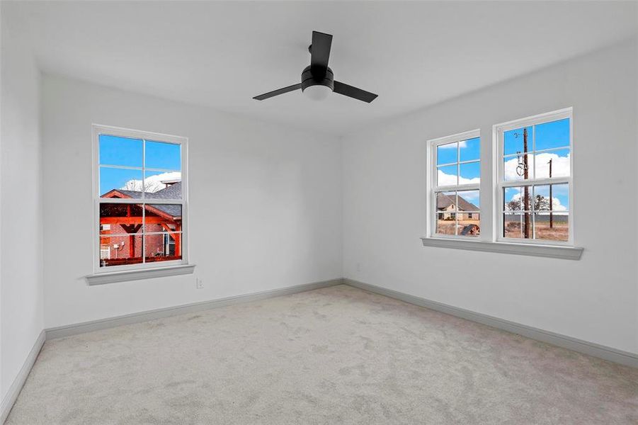 Empty room featuring ceiling fan and carpet flooring