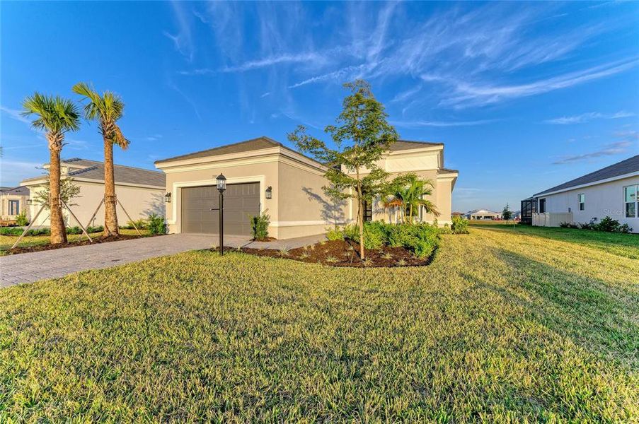 Front exterior of a new home in Esplanade at Azario Lakewood Ranch, Lakewood Ranch, FL, highlighting curb appeal (Image 1). Front exterior of a new home in Esplanade at Azario Lakewood Ranch, Lakewood Ranch, FL, highlighting curb appeal (Image 1).