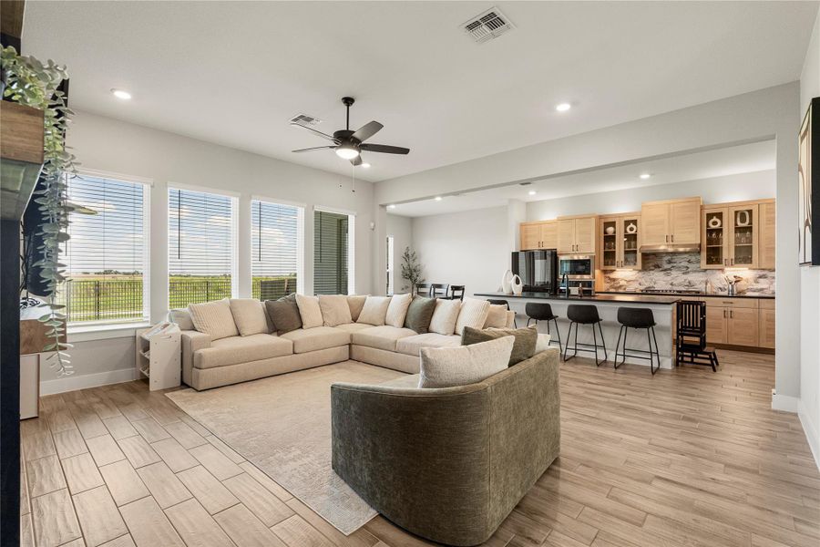 An open concept living area connects seamlessly with a modern kitchen, featuring a spacious island and panoramic window views. An open concept living area connects seamlessly with a modern kitchen, featuring a spacious island and panoramic window views.
