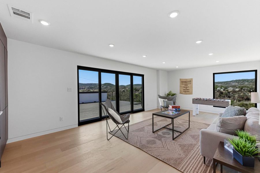 Living area with light wood-style floors and recessed lighting