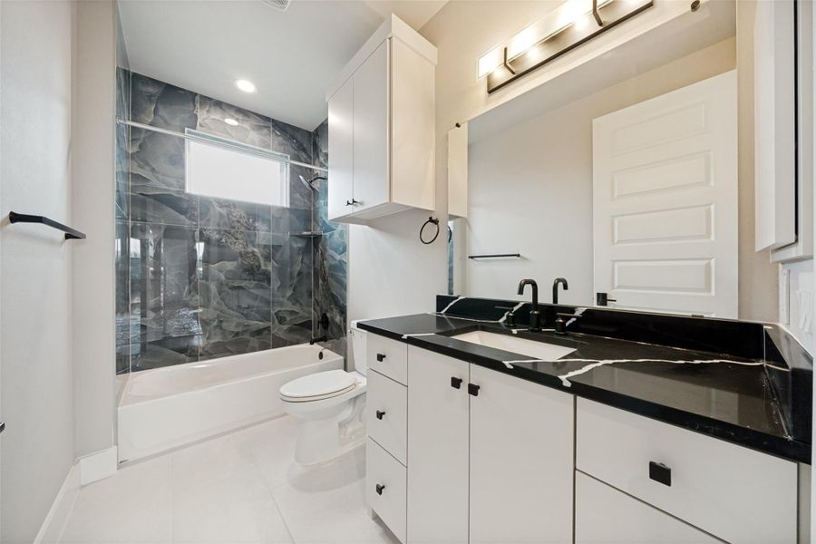 A well-appointed bathroom features a modern vanity with a dark marble countertop, offering refined elegance. A well-appointed bathroom features a modern vanity with a dark marble countertop, offering refined elegance.