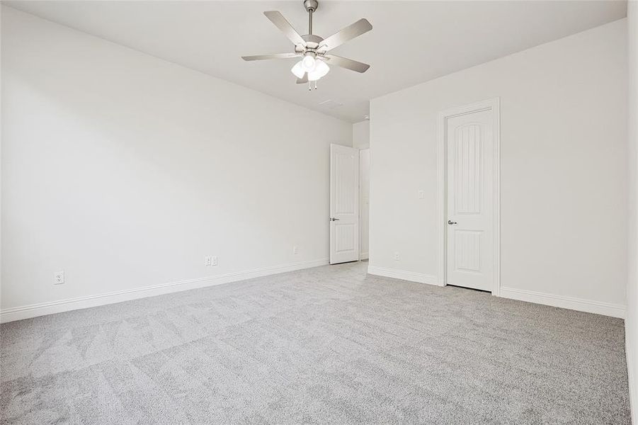 Carpeted spare room featuring ceiling fan