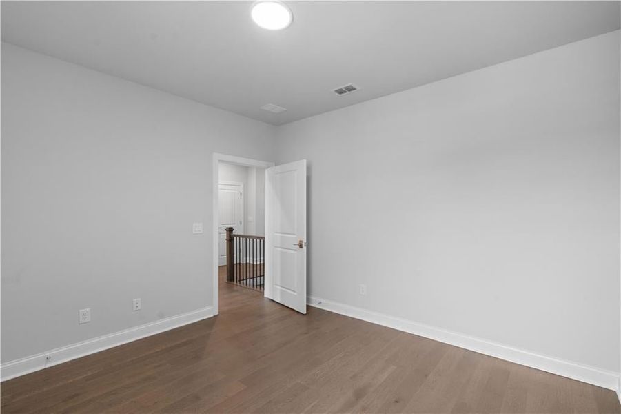 Unfurnished room with dark wood finished floors and baseboards Unfurnished room with dark wood finished floors and baseboards