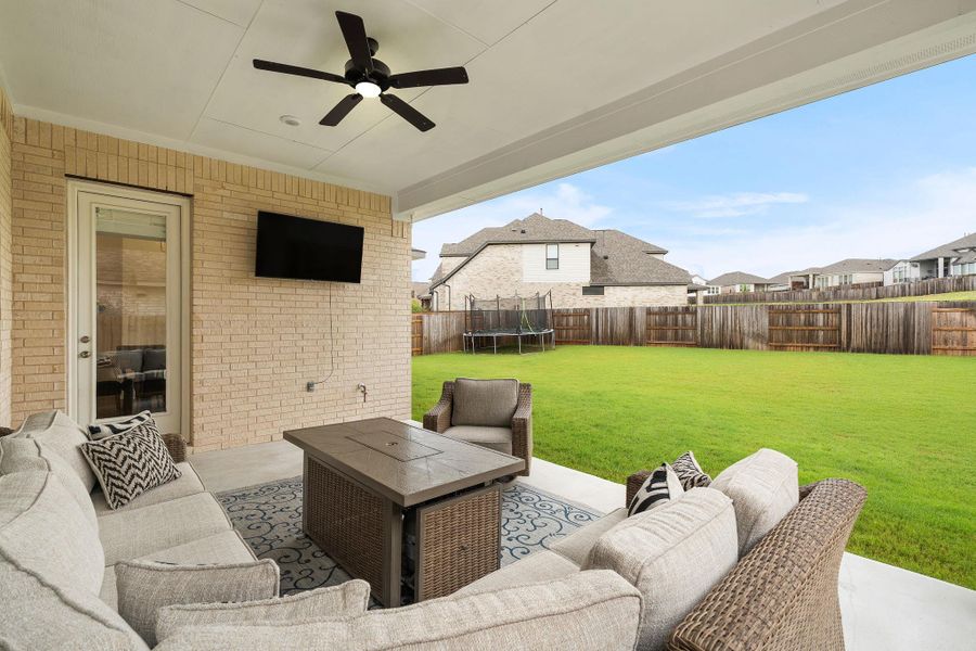 An inviting covered patio with ceiling fan extends living space outdoors.