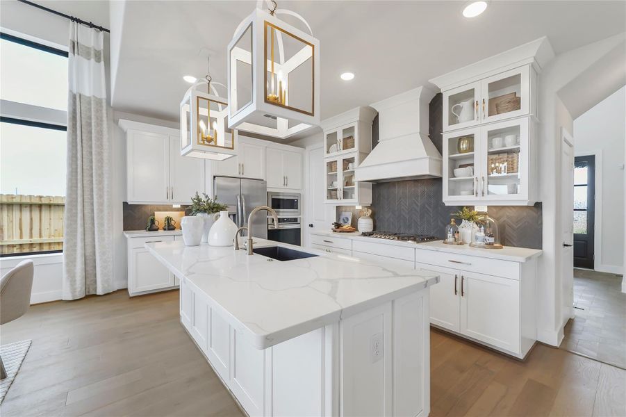 **REPRESENTATION PHOTO OF THE SAME FLOOR PLAN, FINISHES WILL VARY** This immaculate kitchen features a spacious walk-in pantry, buit-in appliances, ample counterspace, and a single bowl sink. Complete with a walter filtration system on the island and reverse osmosis!