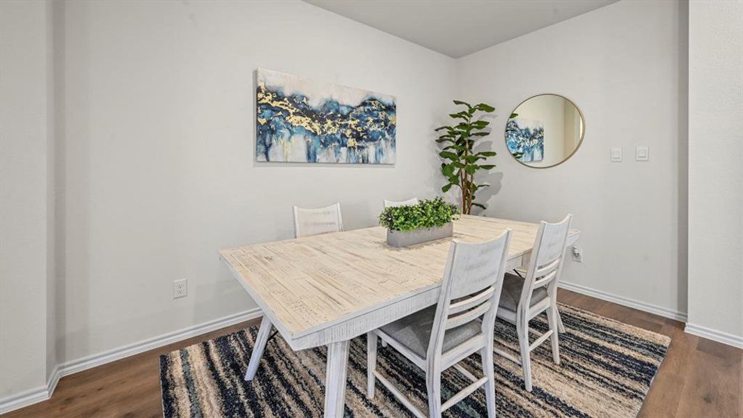 Dining space with dark wood-style floors and baseboards