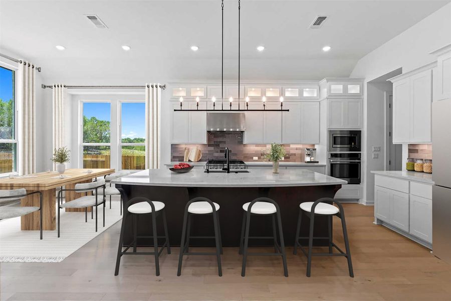 Kitchen featuring backsplash, range hood, a kitchen breakfast bar, stainless steel appliances, and light countertops