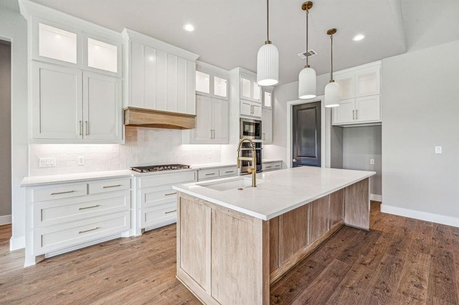 Kitchen featuring decorative backsplash, white cabinets, and hardwood / wood-style floors