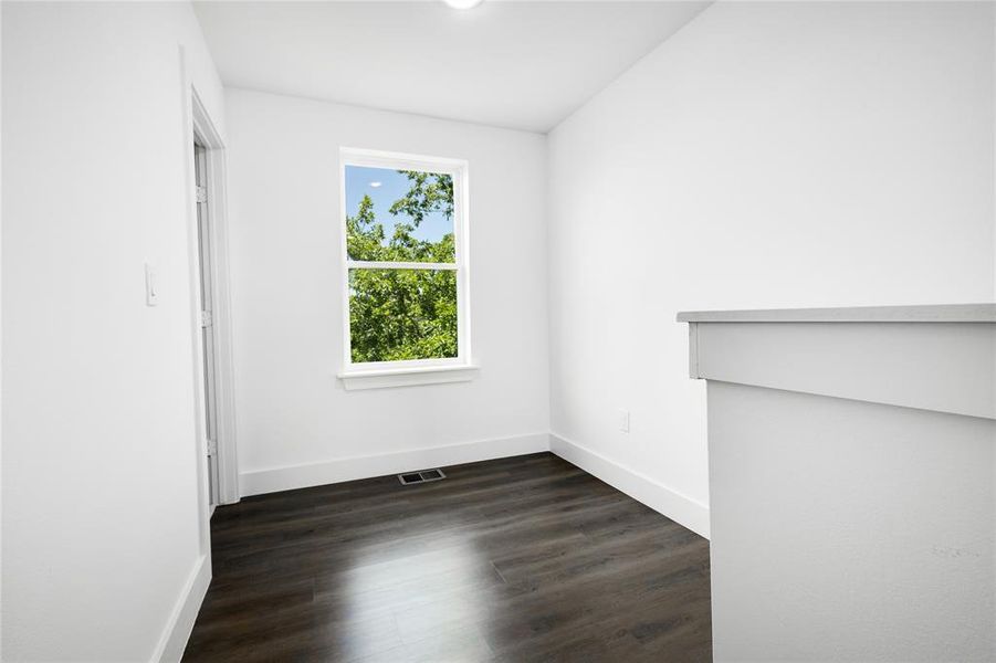 Spare room with dark wood-type flooring